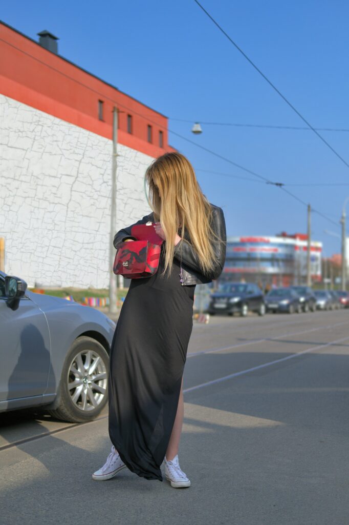 Young woman looking for key from her car in the bag